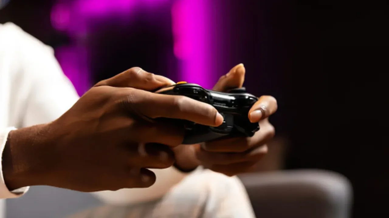 A close-up shot of a gamer's hands gripping a black gamepad controller with thumbsticks positioned, set against a softly blurred purple neon ambient lighting background, highlighting the precision required when fine-tuning controller sensitivity settings.