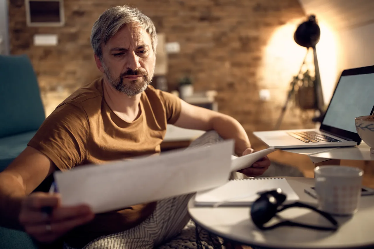 businessman pajamas analyzing paperwork while working late evening home