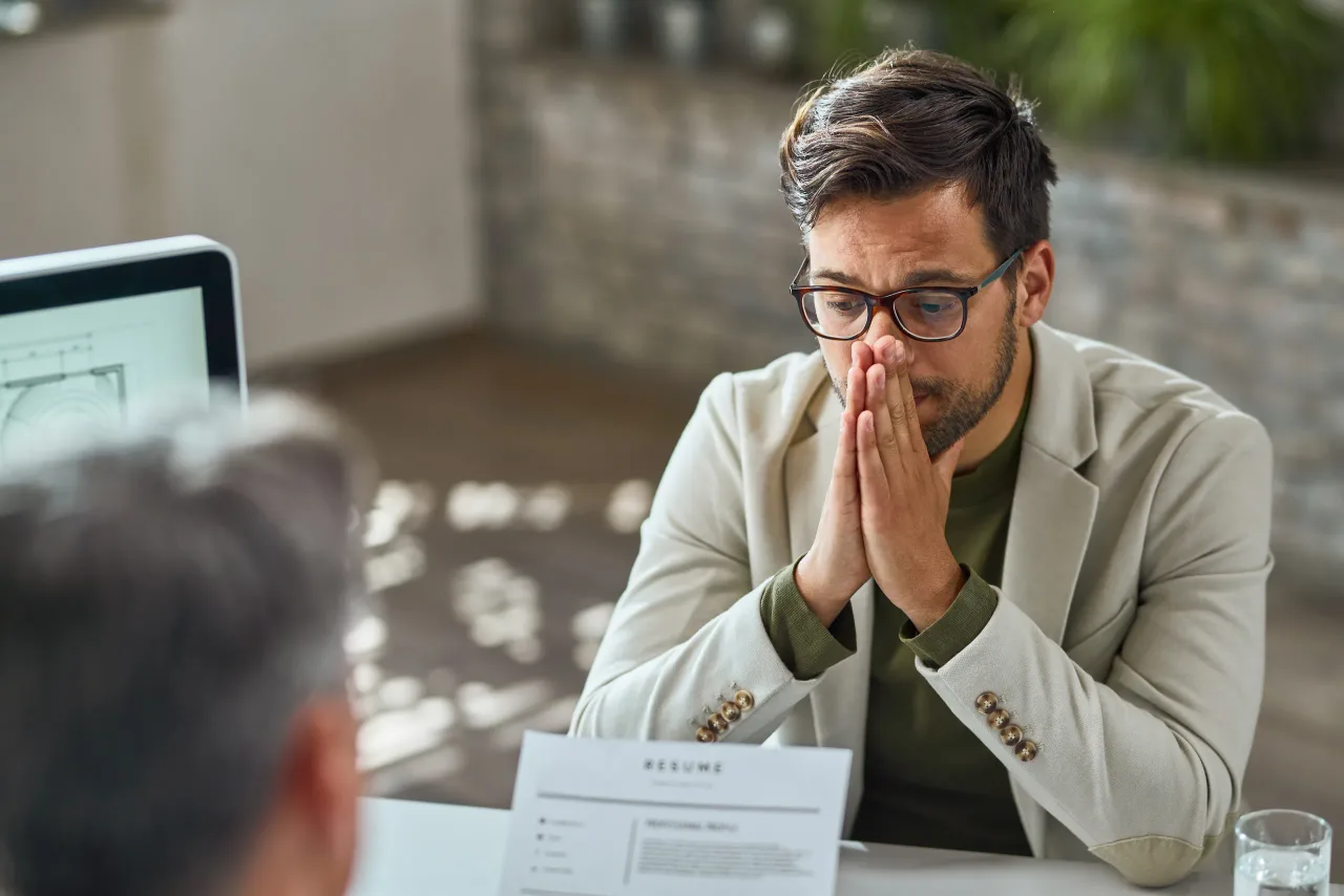 distraught young man feeling uncertain while having job interview office