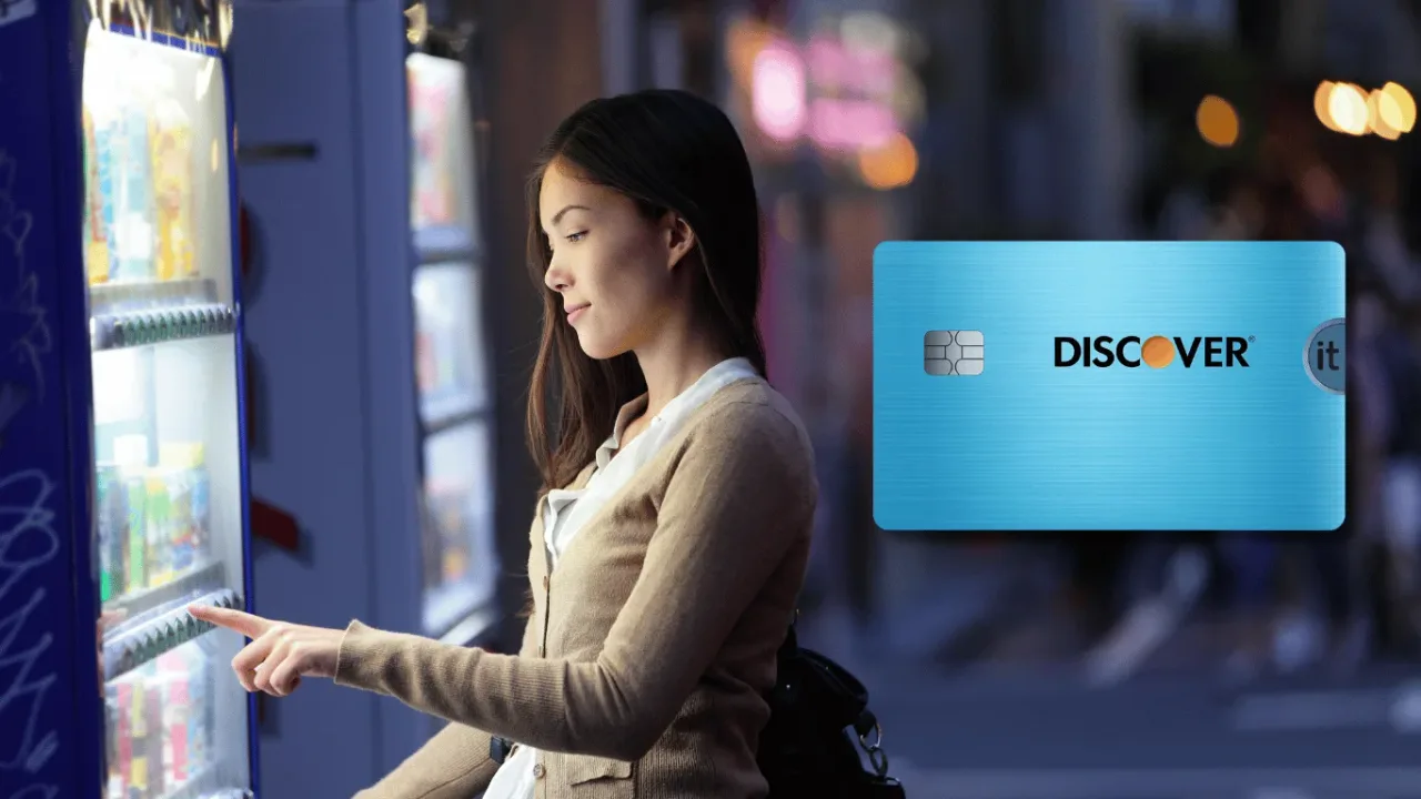 Mujer usando una máquina expendedora por la noche junto a una tarjeta de crédito Discover it azul.