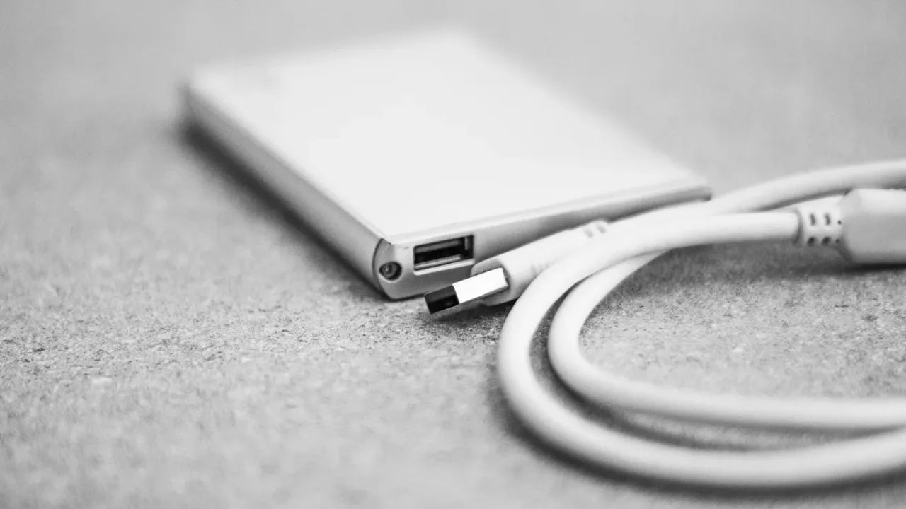 USB port selection for low latency peripherals, showing a USB-C cable and laptop adapter used to optimize device connectivity, response time, and overall USB performance.