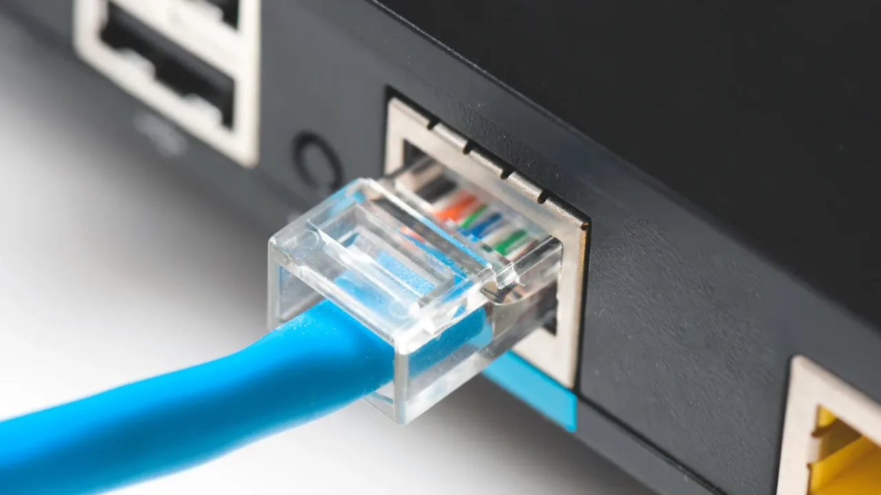 Close-up of an Ethernet Cable connected to an RJ45 network port on a router or desktop computer, illustrating a wired internet connection for stable, low-latency network performance.