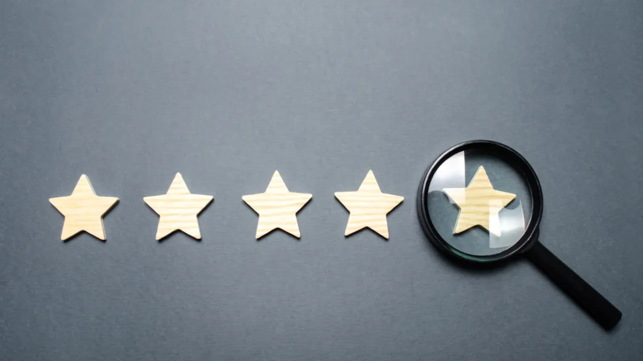 Wooden star rating icons with a magnifying glass highlighting the fifth star, representing Regional Rating and the evaluation of local performance and customer reviews."