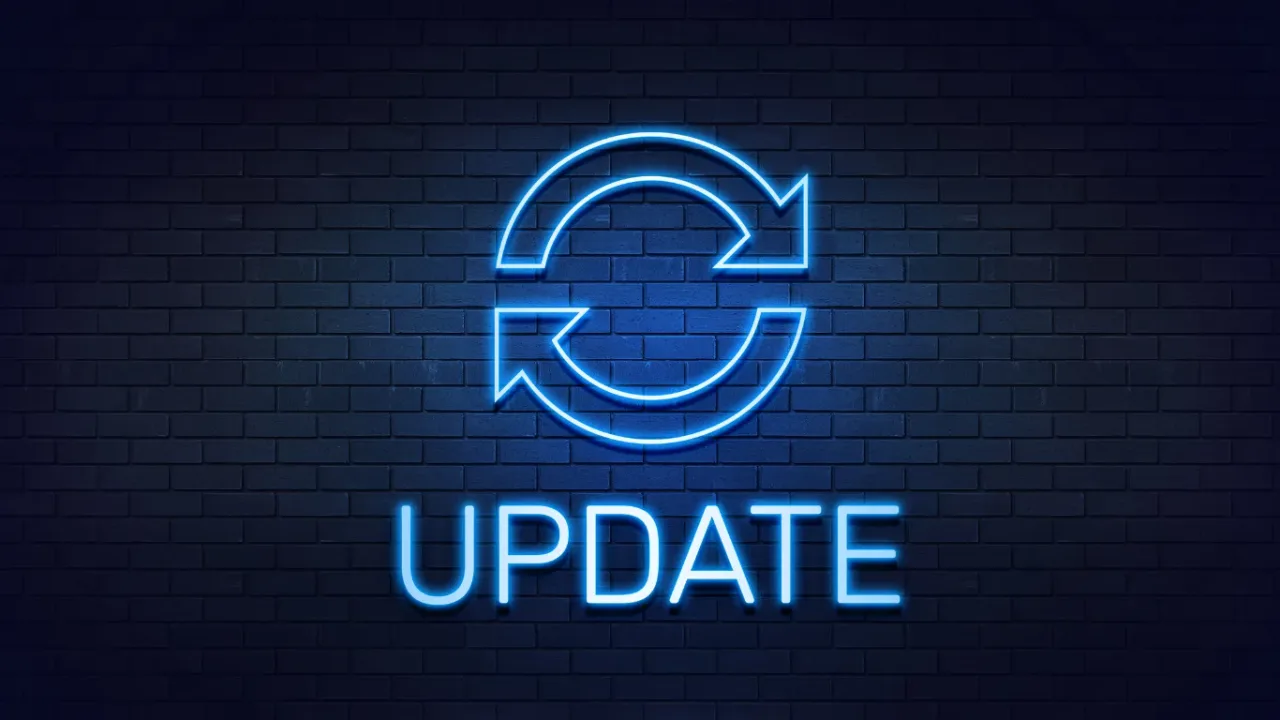 Neon update icon with circular arrows above the word 'UPDATE' on a dark brick wall, representing a Game Engine Update with new features, performance improvements, and system enhancements.