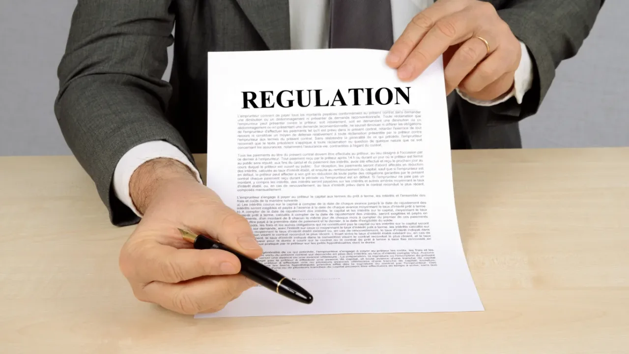 Business professional holding a regulation document and pen, representing Embargo Practices and legal compliance.