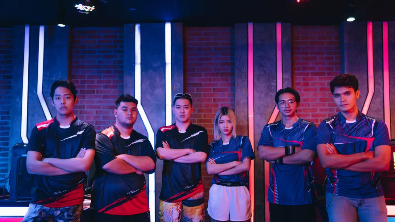 Esports team posing together under colorful lights in a professional Esports Broadcast Studio.