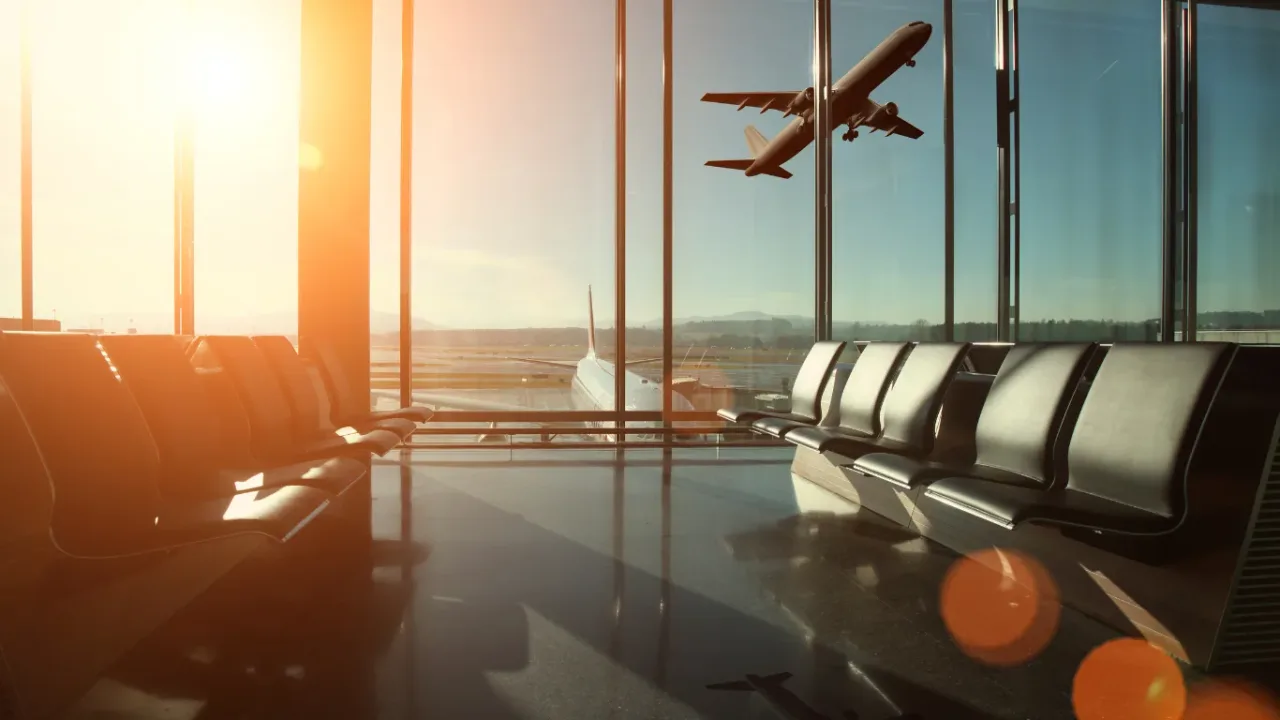 Airport terminal with planes visible through large windows, illustrating travel logistics and Season Scheduling.