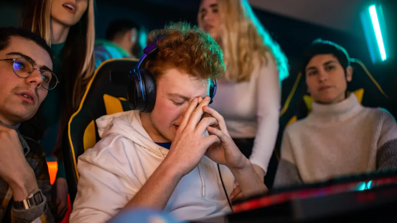 A frustrated esports player reacts during a gaming session as a Match Fixing Detection System monitors competitive integrity.