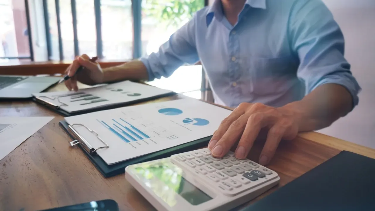 A professional reviews financial charts and calculations while planning an Event Funding Program budget.