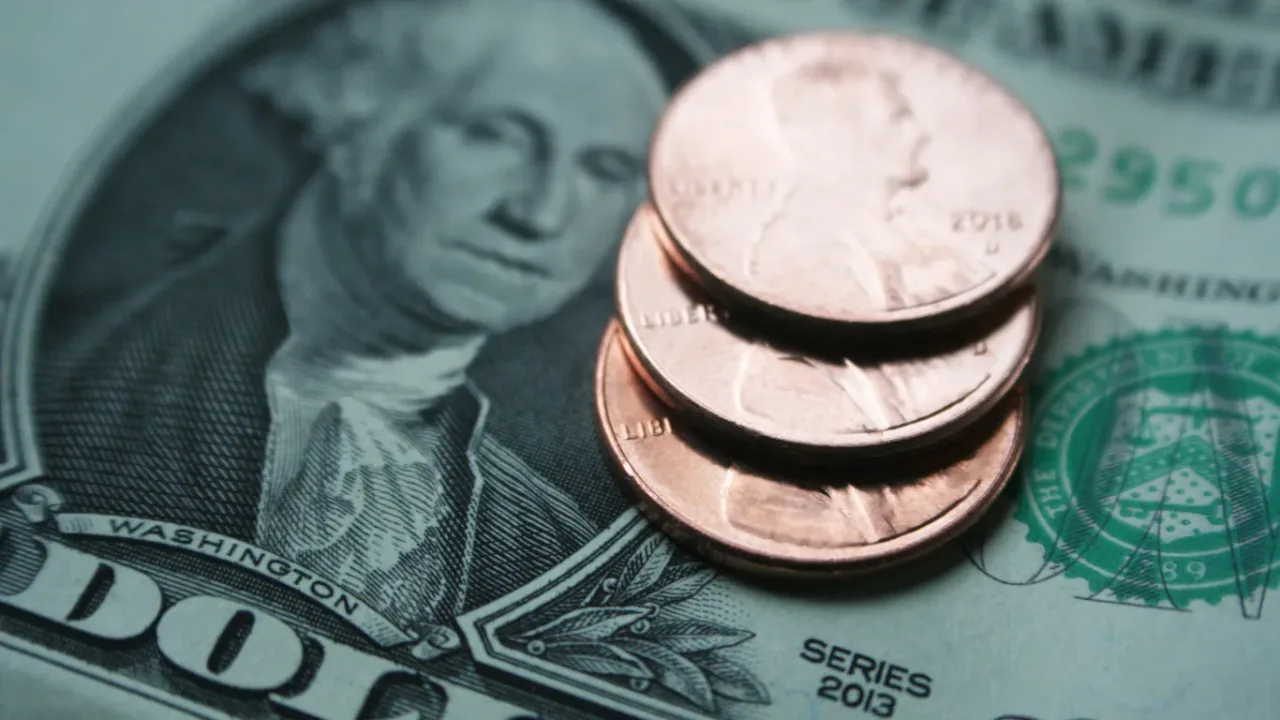 US dollar bills and coins illustrate financial considerations surrounding the League Minimum Wage.