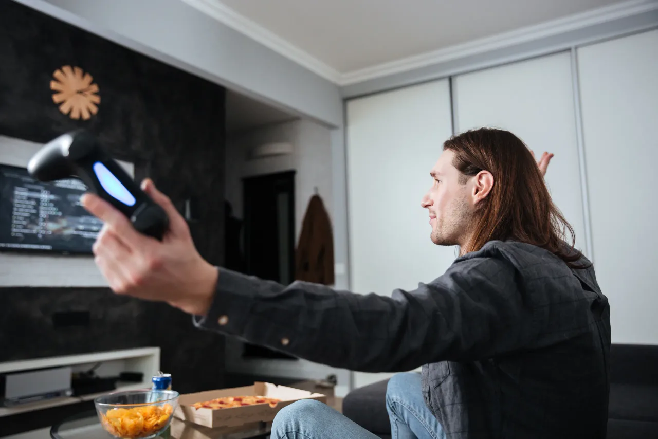 side view image young sad man gamer sitting home
