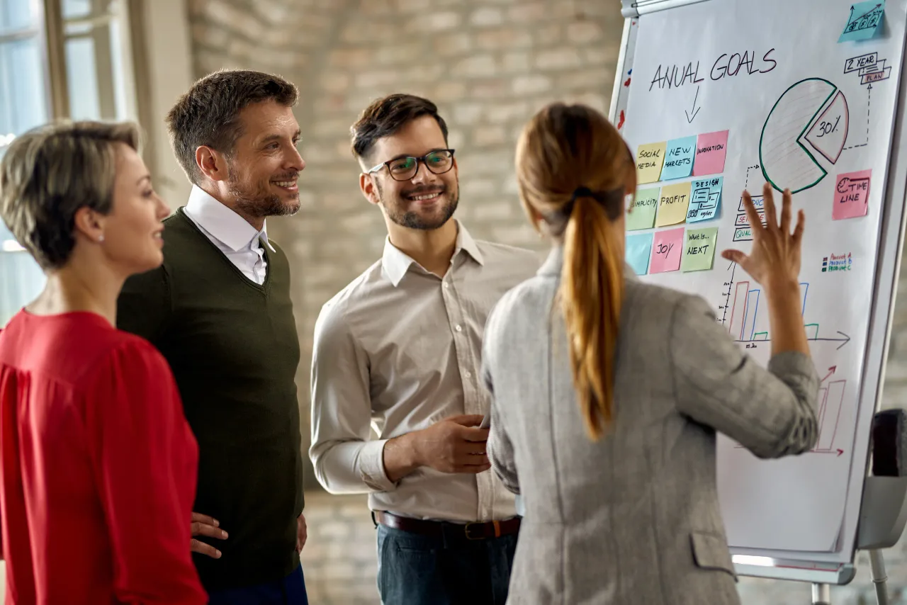 happy business team cooperating while analyzing their business progress whiteboard office