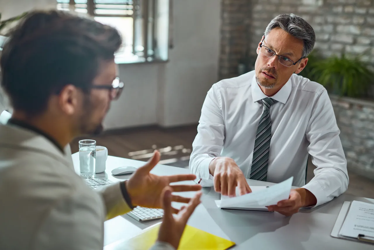 member human resource team talking with candidate while reviewing his resume job interview office
