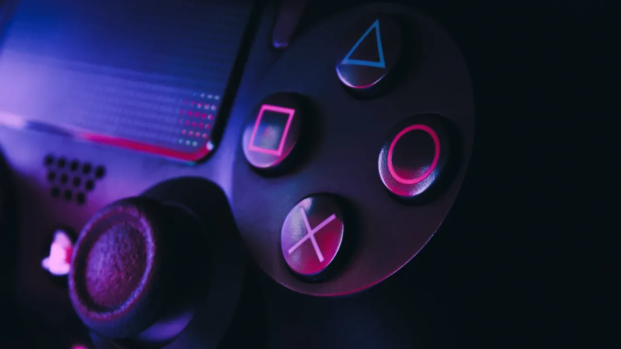 Close-up of a gaming controller illuminated in purple neon light, perfect for players looking for the best Controller Mapping Tips to optimize their gameplay.
