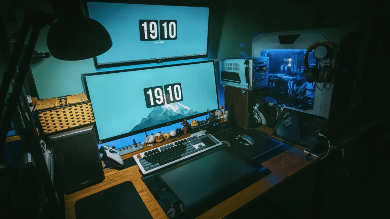 A high-tech desk setup with dual stacked monitors in a Multi-Monitor Configuration for Expanded Gameplay, featuring mechanical keyboards and vibrant gaming lighting.