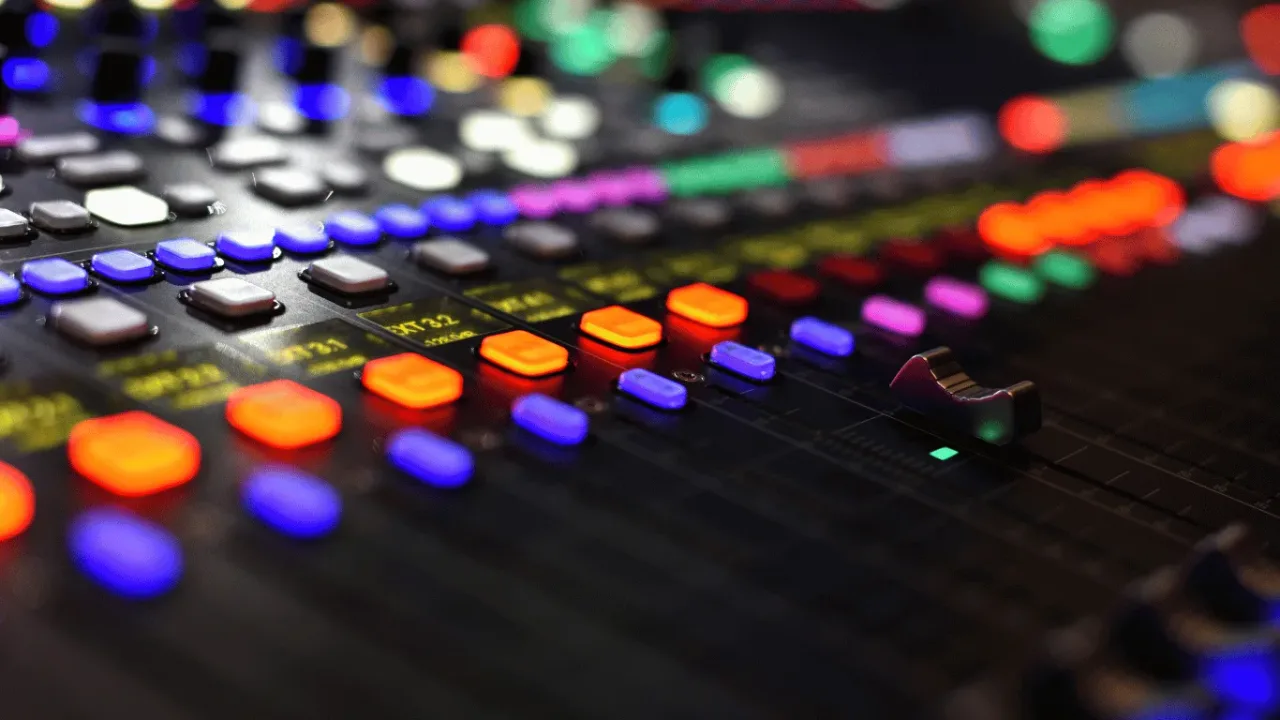 A professional mixing console glowing with vibrant buttons, a visual reminder to fine-tune your Audio Equalizer Settings for Competitive Advantage in every game.